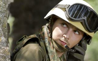 A soldier in protective gear that makes use of polycarbonates, including safety glasses, helmet, and Kevlar jacket.